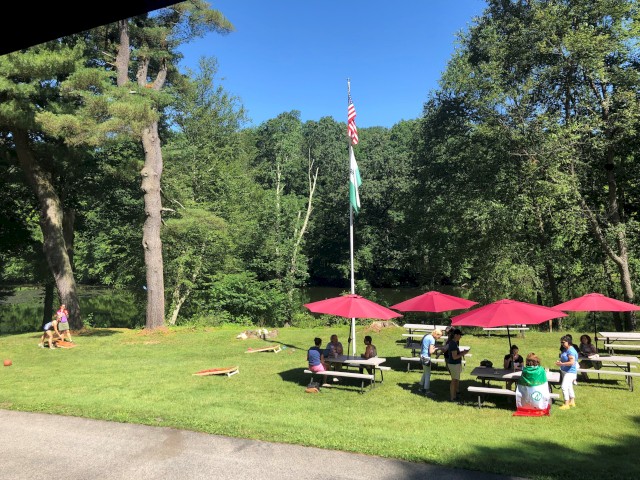 Open space with picnic tables, red umbrellas and games